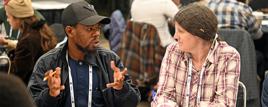 Two people carry on an animated discussion in a conference setting.